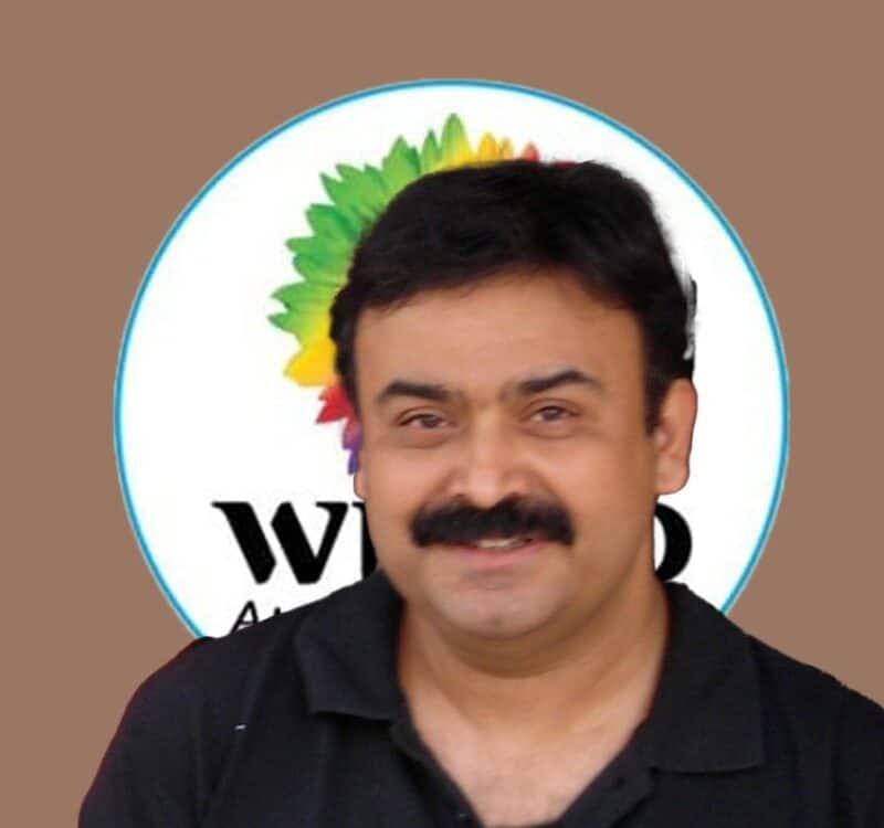 Abhijit Bhaduri person smiling in front of a colorful company logo. Could this be the Chief Learning Officer, or perhaps the Chief what? The mystery continues!