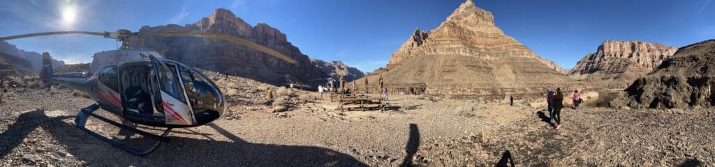A helicopter sits on a rocky landing pad in the Grand Canyon, ready to whisk visitors away. A happy life and a meaningful life are not the same thing, but this view offers both!